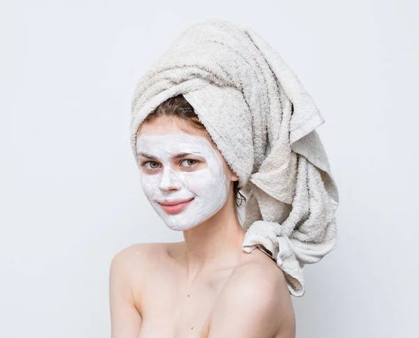 Femme avec serviette sur la tête épaules nues masque blanc sur les soins de la peau du visage — Photo