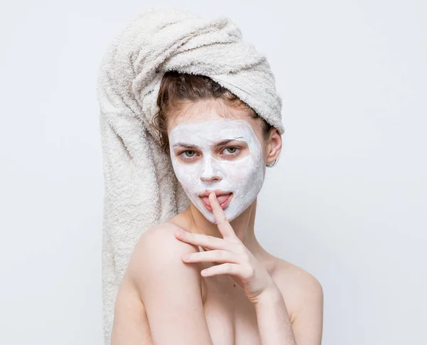Mujer con hombros desnudos con una toalla en la cabeza cuidado de la piel máscara facial — Foto de Stock