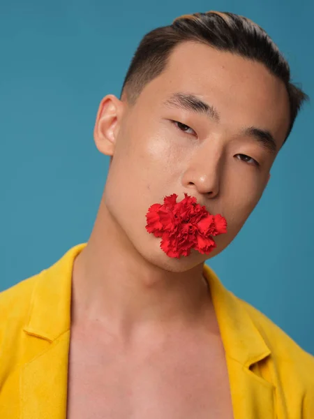 Retrato de un hombre coreano con una flor roja en la boca y una chaqueta amarilla —  Fotos de Stock