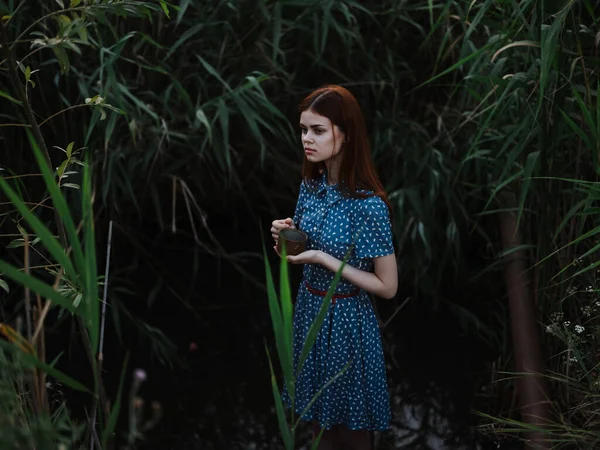 Γυναίκα σε εξωτερικούς χώρους κοντά στο πράσινο γρασίδι και ένα ποτάμι στο παρασκήνιο — Φωτογραφία Αρχείου