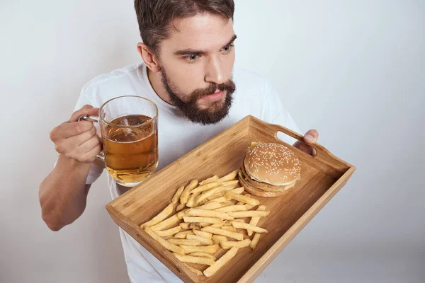 Człowiek z kubkiem piwa fast food dieta jedzenie alkohol zabawa lekkie tło — Zdjęcie stockowe