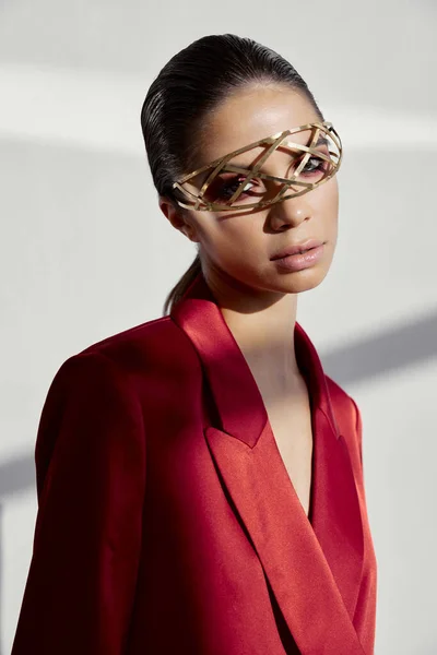 Portret van een stijlvolle vrouw in een rode jas en sieraden op haar gezicht ijzeren bril nieuwe technologie — Stockfoto