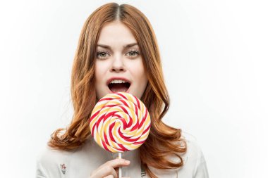 Çok renkli, yuvarlak lolipoplu çekici bir kadın. Duygularını tatlandırıyor.