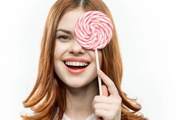 Atractiva mujer cubriendo la cara con caramelo caramelo emoción de cerca —  Fotos de Stock
