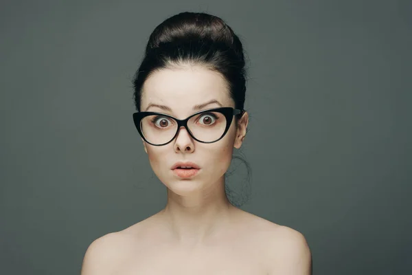 Pretty woman naked shoulders gathered hair glasses emotions Stock Photo