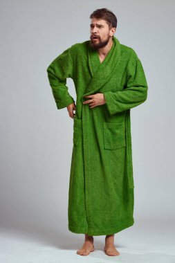 Yeşil cüppeli sakallı bir adam dinleniyor.