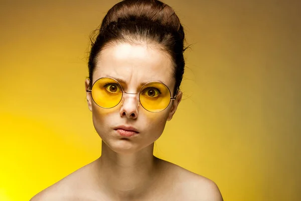 Woman with bare shoulders yellow glasses collected hair emotions — Stock Photo, Image