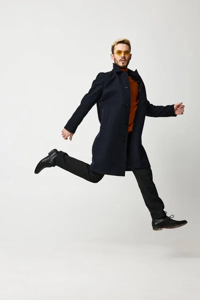 Lindo rubio chico corriendo a un lado en moda ropa tendencia de la temporada pantalones abrigo — Foto de Stock