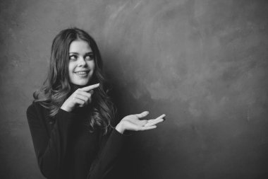 Siyah beyaz fotoğrafçı bir kadının portresi. Elleriyle işaret ediyor. Boşluğu kopyala.