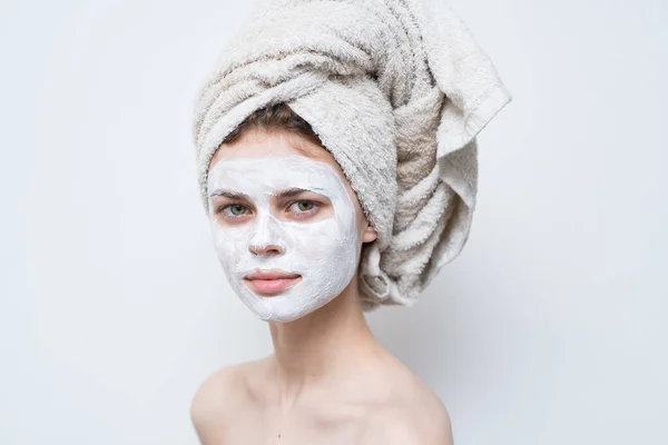 Hübsche Frau mit einem Handtuch auf dem Kopf Gesichtsmaske nackten Schultern attraktives Aussehen — Stockfoto