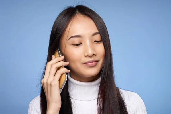 Милая азиатская женщина говорит по телефону технологии синий фон — стоковое фото