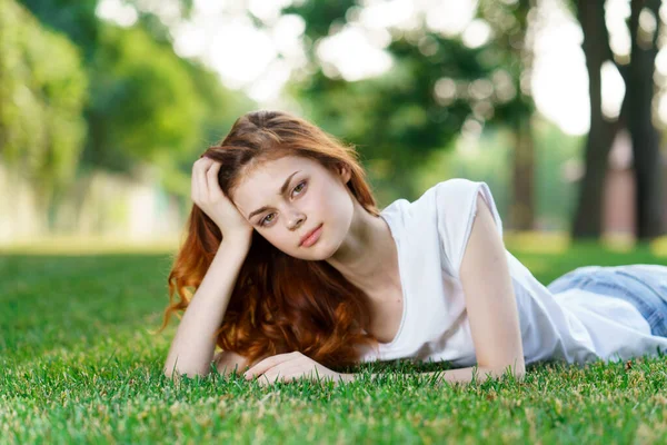 Frau liegt auf dem Gras im Park — Stockfoto