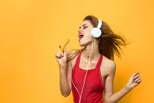 Mulher emocional em fones de ouvido brancos escuta música divertida estilo de vida fundo amarelo — Fotografia de Stock