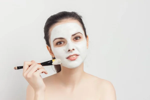 Женщина с голыми плечами применять кисть маски для лица уход за кожей спа-процедуры — стоковое фото