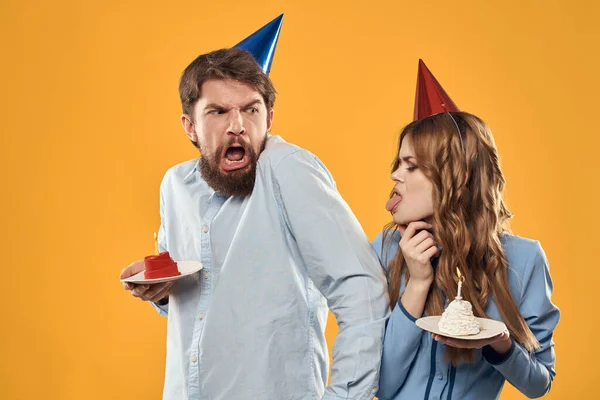 День народження чоловік і жінка в кепці з тортом на жовтому тлі обрізаний вид — стокове фото