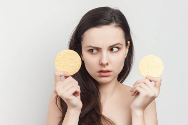 Çıplak omuzlu, cilt makyajlı bir kadın.