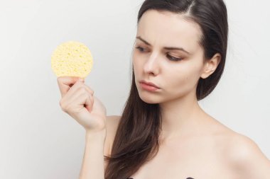 Çıplak omuzlu, cilt makyajlı bir kadın.