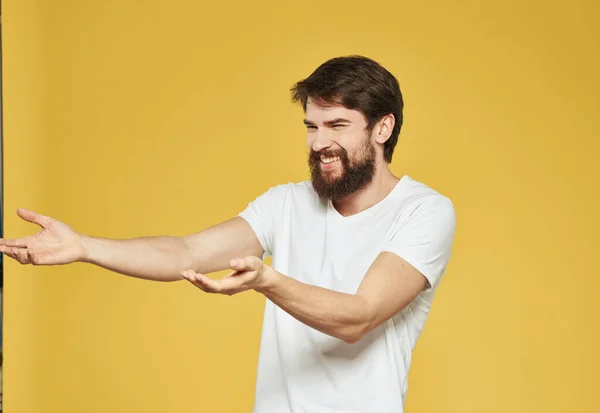 Modello maschio gesticolando con le mani su uno sfondo giallo vista ritagliata — Foto Stock