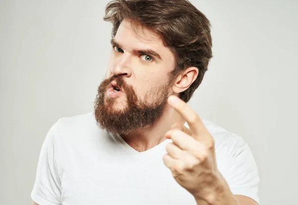 El tipo de la camiseta muestra el dedo índice y las emociones modelan una mirada indignada — Foto de Stock