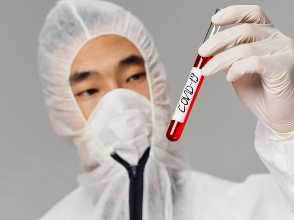 Male laboratory assistant Asian appearance blood tests for covid-19 close-up — Stock Photo, Image