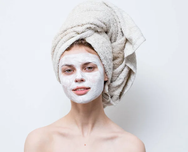 Bonita mulher grooming branco máscara facial e toalha na cabeça — Fotografia de Stock