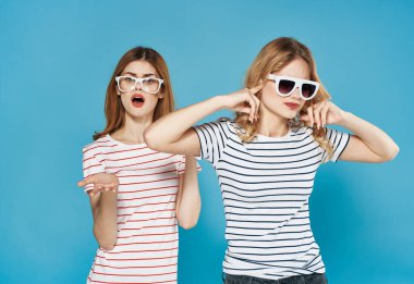 İki kız arkadaş duygularının uyuşmazlığı mavi arka planda tartışır