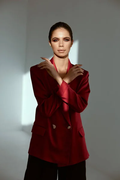 Morena atraente na jaqueta vermelha mantém as mãos perto do modelo de charme rosto — Fotografia de Stock