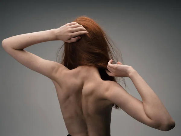 Naken kvinna gestikulerar med händerna rött hår ljus bakgrund — Stockfoto