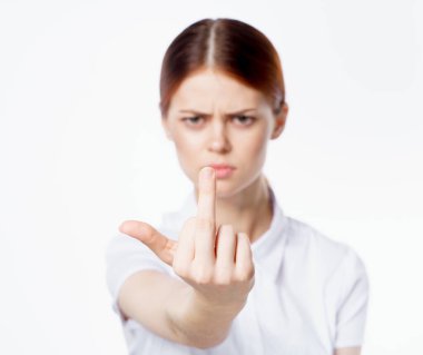 Kızıl saçlı, beyaz gömlekli, el duygularıyla hareket eden stüdyo manzaralı bir kadın.