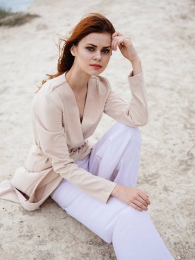 Açık havada açık renk kazaklı romantik kızıl saçlı kadın.