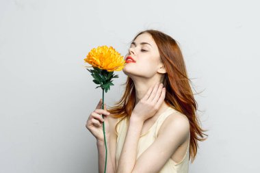 Gülümseyen kadın... kırmızı dudaklar... sarı çiçek...