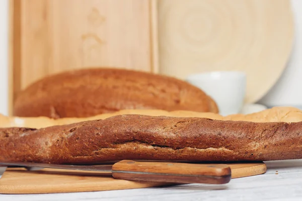 Pão longo assado produtos de corte de pão de tábua — Fotografia de Stock