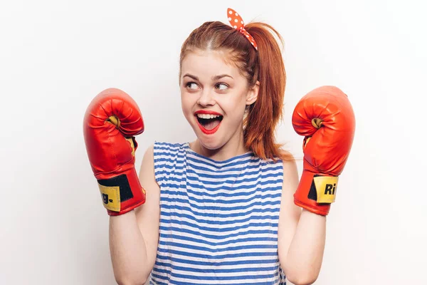 Jolie femme en t-shirt rayé gants de boxe entraînement fond clair — Photo