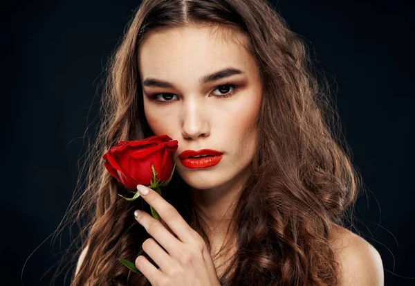 Romantikus nő, fekete háttérrel, piros virággal — Stock Fotó