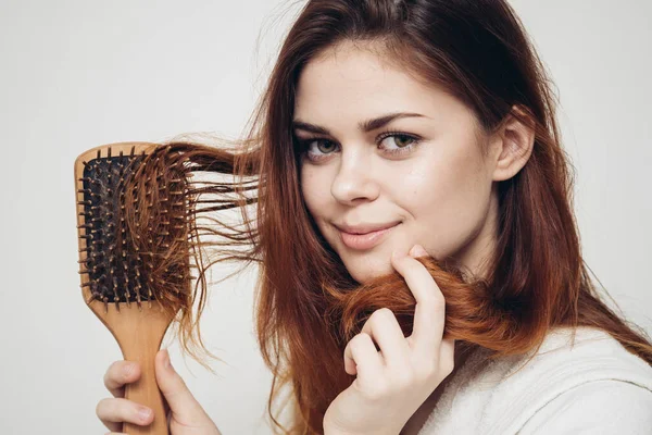 Mulher modelo com pente cabelo saudável em fundo claro roupão branco — Fotografia de Stock