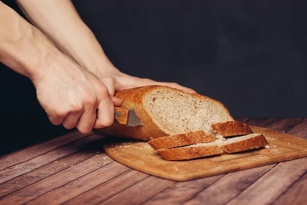 Krojenie świeżego bochenka chleba na desce do krojenia — Zdjęcie stockowe