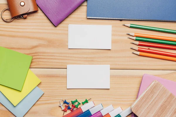 Névjegykártyák színes ceruzák íróasztal írószer felülnézet — Stock Fotó