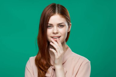 Pembe gömlekli güzel kadın yeşil arka planda el ele tutuşuyor.