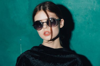 Güzel kadın güneş gözlüğü şaşaalı yeşil arka plan