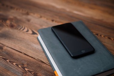 ahşap kapaklı cep telefonu ve kitap