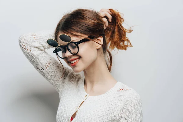 Mujer en suéter blanco gafas de moda de estilo moderno recortado aspecto y fondo claro — Foto de Stock