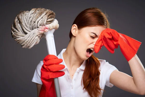 Limpieza señora cubre su nariz con sus dedos desagradable olor fregona en la mano limpieza descontento — Foto de Stock