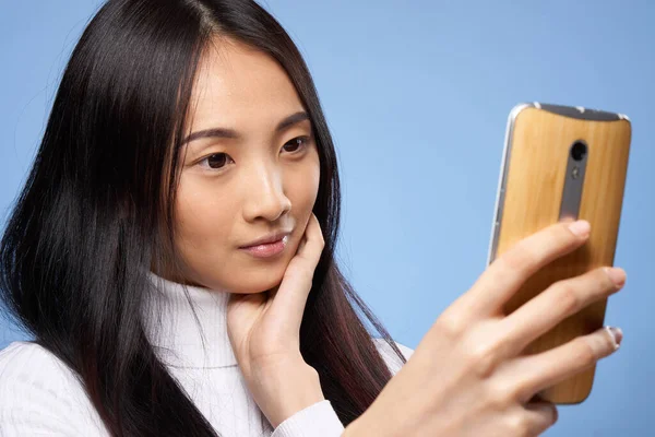 Atractivo mujer asiático apariencia teléfono en manos tecnología estilo de vida azul fondo — Foto de Stock