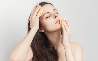 Güzel esmer, çıplak omuzlu, elinde süngerle kırpık manzaralı.