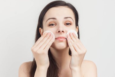 Esmer, dalgalı saçlı, çıplak omuzlu, yüzünün yanında sünger gibi.