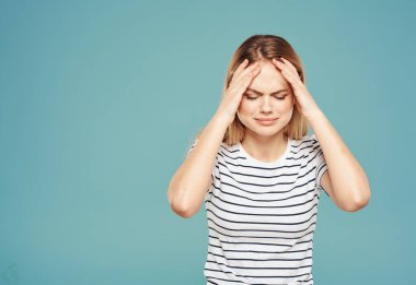 Üzgün kadın ellerini mavi arka plan yakın plan fotokopisi ile yüzüne dokunduruyor.