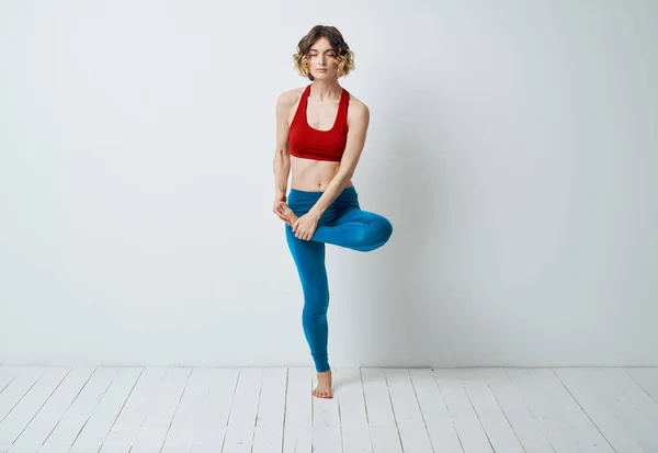 Kvinna i leggings böjda hennes ben och Yoga Fitness meditation — Stockfoto