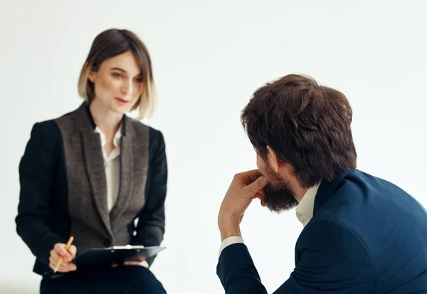 Mulher e homem em um casaco em uma entrevista de emprego de fundo leve — Fotografia de Stock