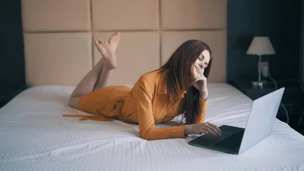 Mulher no quarto está na cama laptop tecnologia de estilo de vida de trabalho — Fotografia de Stock