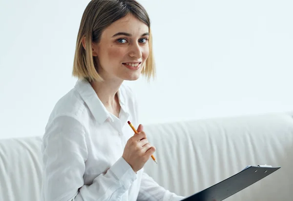 Psychologin mit Aktenmappe sitzt auf der Couch in einem hellen Raum — Stockfoto